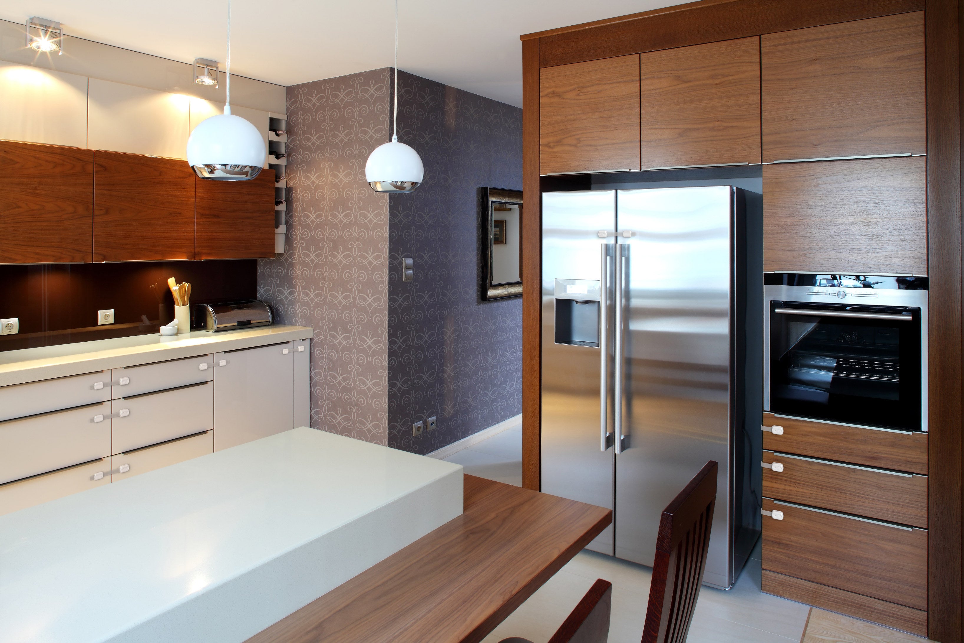 Modern kitchen with stainless steel French door refrigerator and wood cabinetry showing unsecured appliance doors
