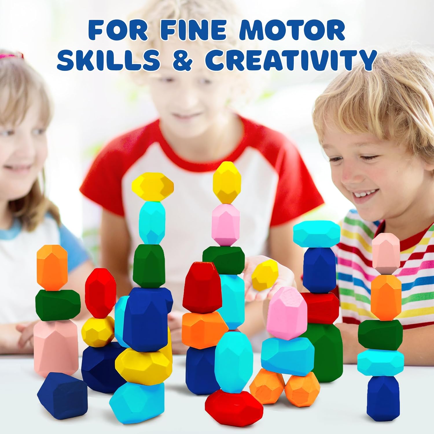 Two kids stacking colorful wooden balancing stones into tall towers at a white table, building fine motor skills
