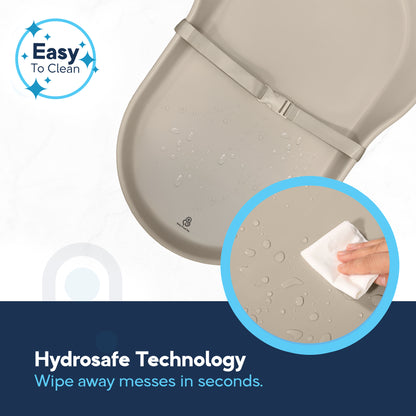 Hand wiping water droplets off beige EVA foam changing pad surface, Hydrosafe wipe-clean technology