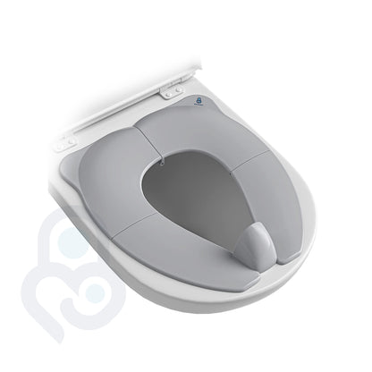 Grey foldable portable toilet seat trainer seated inside open white toilet, overhead angle showing reduced opening